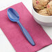 A bowl of ice cream with a navy blue Creative Converting plastic spoon on a napkin.