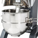 A Vollrath stand mixer with a stainless steel bowl on a metal bar.
