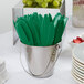 A bucket filled with Creative Converting emerald green plastic knives.