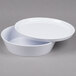 A white round bowl with a lid on a white surface.