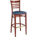 A Lancaster Table & Seating metal ladder back bar stool with navy vinyl seat and mahogany wood grain finish.