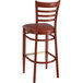 A Lancaster Table & Seating metal ladder back bar stool with a mahogany wood grain finish and a burgundy vinyl cushion.