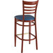 A Lancaster Table & Seating metal ladder back bar stool with mahogany wood grain finish and navy vinyl seat.