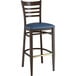 A Lancaster Table & Seating Spartan Series bar stool with a navy vinyl seat and wood grain finish.