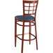 A Lancaster Table & Seating Spartan Series metal bar stool with mahogany wood grain finish and navy vinyl seat.