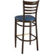 A Lancaster Table & Seating Spartan Series metal ladder back bar stool with a navy vinyl seat and back.