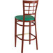 A Lancaster Table & Seating metal bar stool with mahogany and green vinyl seat.