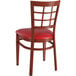 A Lancaster Table & Seating Spartan series wooden window back chair with red cushion.