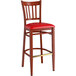 A Lancaster Table & Seating Spartan Series bar stool with a mahogany wood frame and red vinyl cushion.