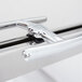 A close up of a Vollrath Roll Top Chafer handle with rubber bumpers.