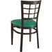 A Lancaster Table & Seating metal chair with green vinyl seat and window back.
