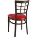 A Lancaster Table & Seating metal restaurant chair with a red vinyl seat and window back.