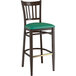 A Lancaster Table & Seating Spartan Series metal bar stool with a green vinyl seat and back.
