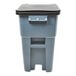 A grey Rubbermaid commercial trash can with a black lid.
