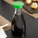 A 5 oz. Town Green Top Soy Sauce bottle on a table.