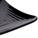A close-up of a black GET Milano square plate with a curved edge.