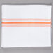 A white cloth napkin with orange stripes.