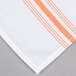 A folded white cloth napkin with orange stripes.