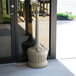 A beige pillar with a black base and a white Commercial Zone Smokers' Outpost cigarette receptacle on top.