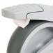 A close up of a Cambro stainless steel swivel caster wheel with a white rim.
