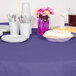 A purple Creative Converting OctyRound table cover on a table with plates and cups.