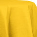 A yellow Creative Converting School Bus Yellow OctyRound tablecloth on a white table.