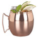 A Libbey copper Moscow Mule mug with a drink, lime, and mint leaves.