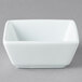 A white square Libbey porcelain bowl on a gray surface.