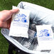 A hand placing a Polar Tech Ice Brix cold pack in a cooler filled with plastic bottles of water.