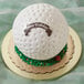 A white cake shaped like a golf ball made using an Ateco stainless steel hemisphere food mold.