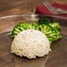A plate with rice and broccoli on a hemisphere cake mold.