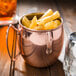 A World Tableware copper Moscow Mule mug filled with french fries.