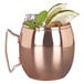 A World Tableware copper Moscow Mule mug with a drink, lime, and mint leaves.