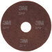 A brown circular 3M Scotch-Brite surface preparation pad with white text.