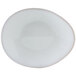 A white Tuxton china plate with an ellipse shape and a small hole in the middle.