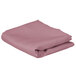 A folded pink rectangular cloth table cover on a white background.