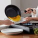 A person cooking an omelet on a Choice portable double burner range.