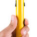 A person holding a yellow Rubbermaid HYGEN Quick Connect Microfiber Mop Handle.