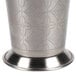 A close-up of a World Tableware stainless steel mint julep cup with an etched pattern.