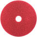A 3M red circular floor pad with a white center.