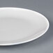 A close-up of a white Chef & Sommelier bone china plate with a small hole in the middle.