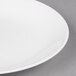 A close up of a Chef & Sommelier white bone china plate with a white rim.