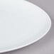 A close-up of a white Arcoroc oval coupe platter.