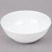 An Arc Cardinal white porcelain bowl with a white rim on a gray surface.