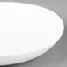 An Arcoroc white porcelain deep coupe plate.
