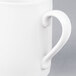 A close-up of a white Arcoroc porcelain mug with a handle.
