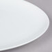 A close-up of an Arcoroc white oval porcelain platter.
