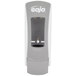 A gray GOJO® ADX-12 manual soap dispenser with a clear plastic cover over the soap.