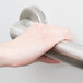 A hand holding a silver Lavex metal grab bar.