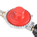A close up of a red and silver Backyard Pro gas regulator with a black handle.